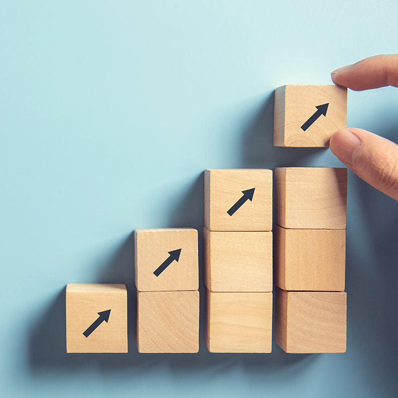 Hand arranging wood block stacking as step stair on paper pink background. Business concept growth success process, copy space.